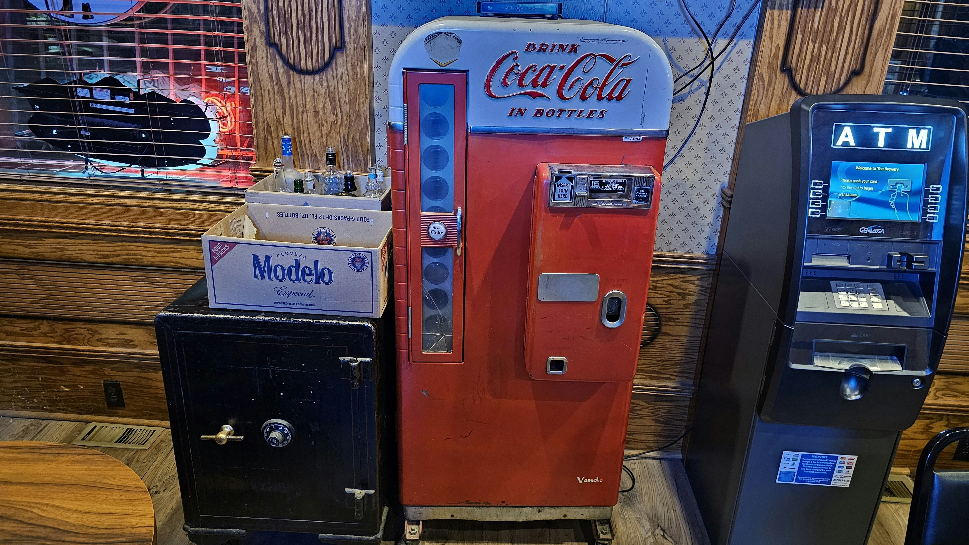 An old-fashioned Coca-Cola machine and an old safe inside The Brewery in Green River sit next to a modern ATM.