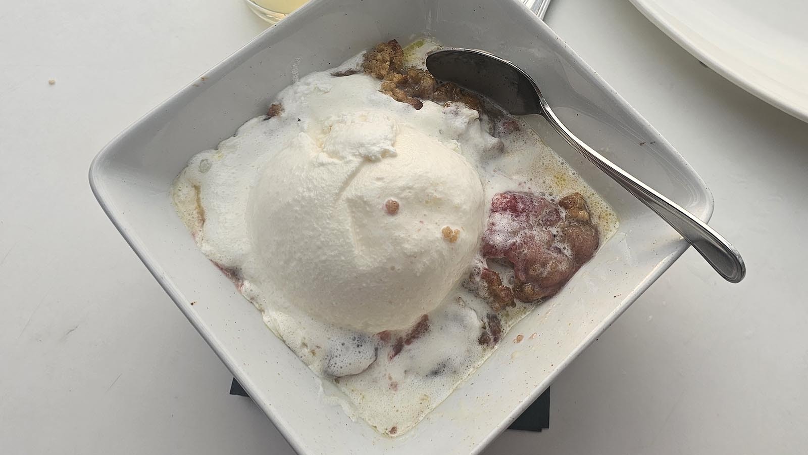 A slice of cherry pie with a huge scoop of ice cream at The Experience.