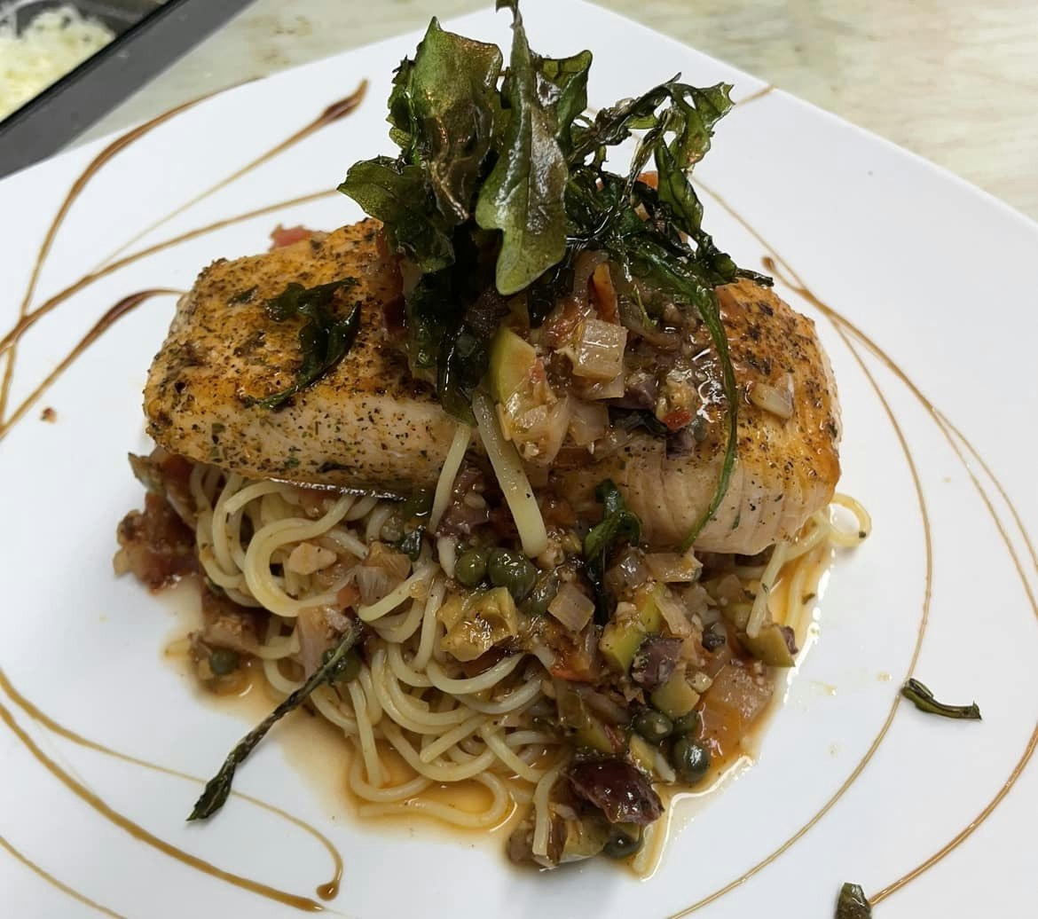 Blackened salmon puttanesca over angel hair pasta with crispy arugula.