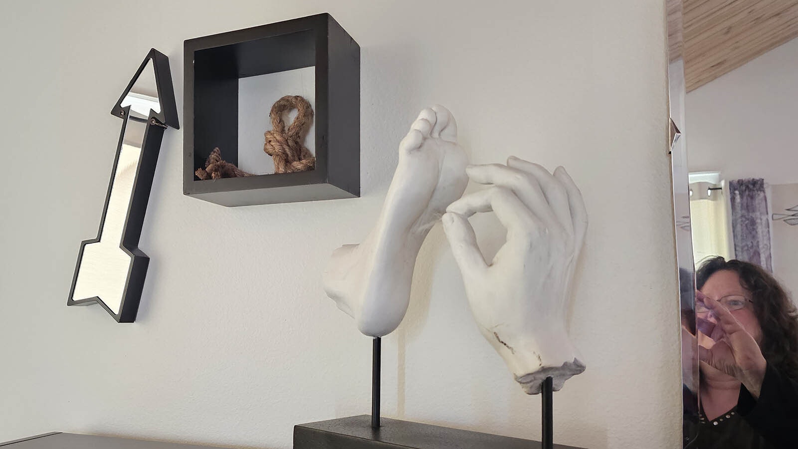 The foot and the hand sculpture are part of a rebus, a puzzle where words are represented by images.