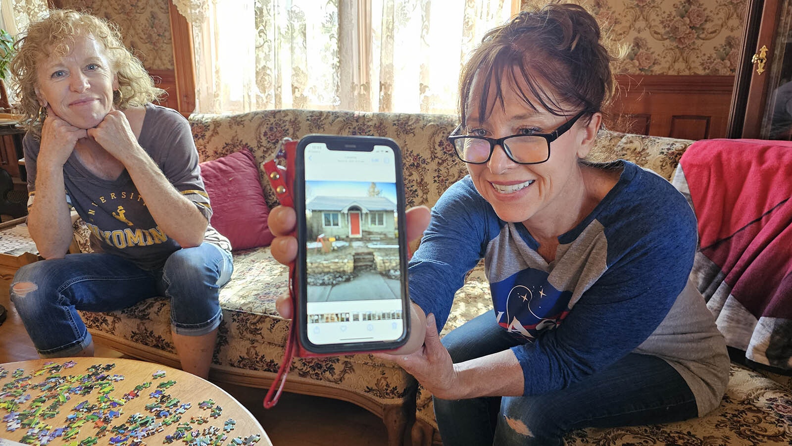 Neika Lundberg and Bethel Medina with a picture of what the Inntrigue looked like before it was redone.