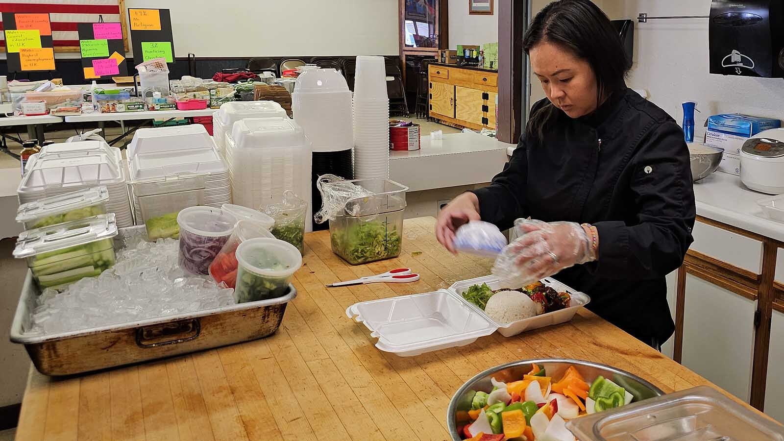 KimChi Vu adds the finishing touches to a to-go box of Shaking Beef, one of The V Cafe's most popular dishes.