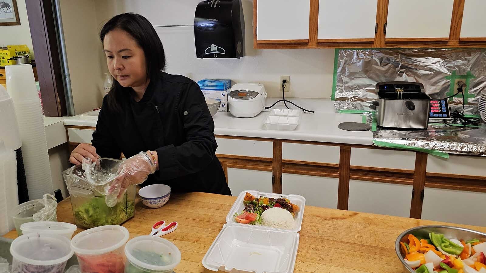 KimChi Vu adds the finishing touches to a to-go box of Shaking Beef, one of The V Cafe's most popular dishes.