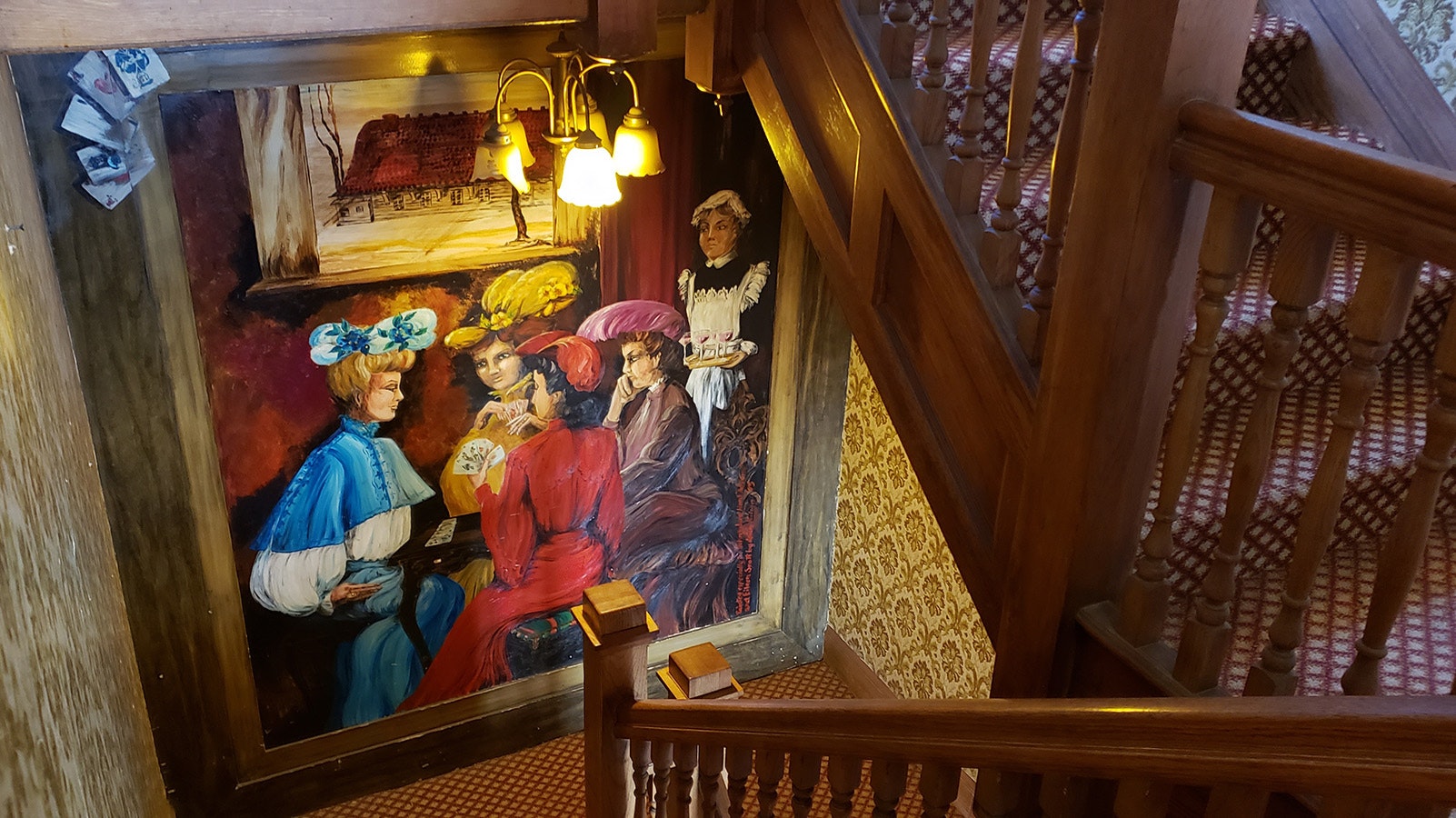 A large painting in the stairwell shows Scott family members about to enjoy wine while playing cards.