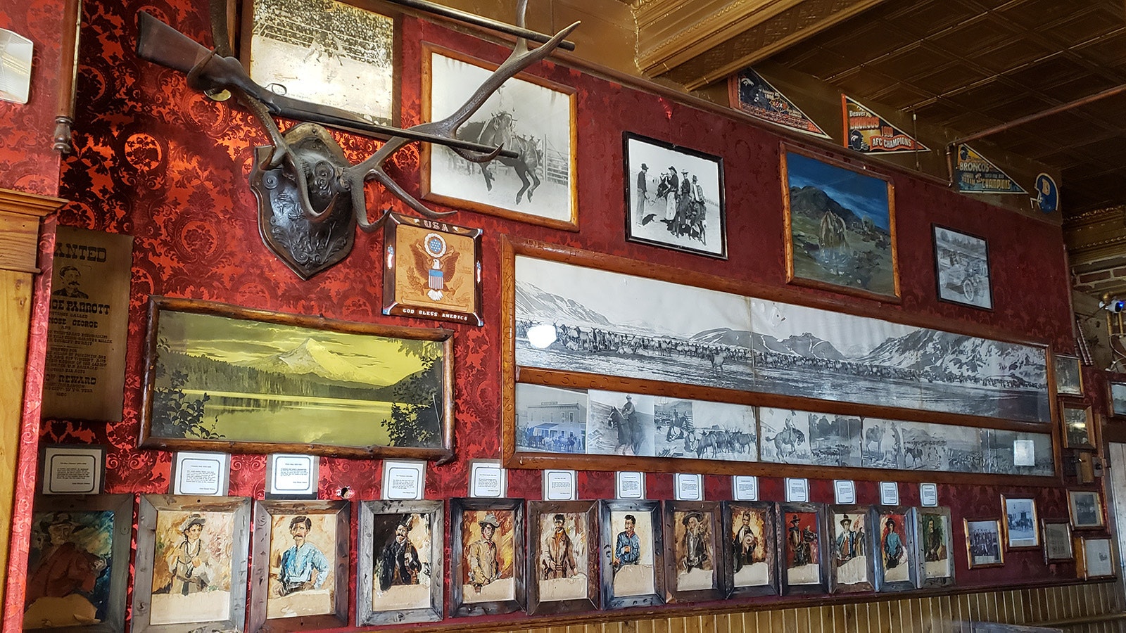 An outlaw wall features portraits of notorious Western people.