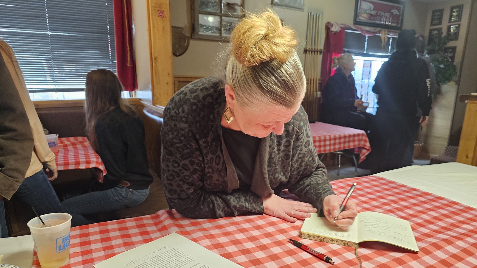 Shuanna Farthing writes a memory down in a guest book at a party in Medicine Bow at the Virginian celebrating the hotel's history and its new owners.