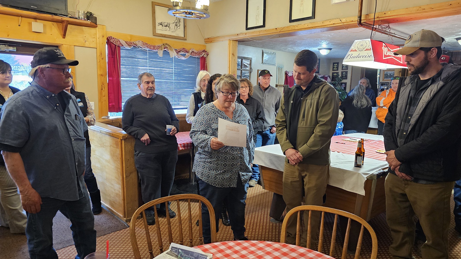 Vernon Scott, far left, looks on as his wife, Vickie, center, reads a letter she wrote to the community and to the new owners of The Virginian Hotel, Aaron Mumford, second from right, and Jesse Baker, far right.
