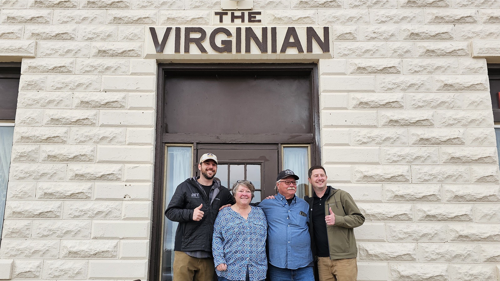 From left, new co-owner Jesse Baker, former owners Vickie and Vernon Scott, and co-owner Aaron Mumford pose for a photograph in front of The Virginian Hotel on Friday. The hotel changed ownership that day, closing out four generations of the Scott family's tenure at the hotel.