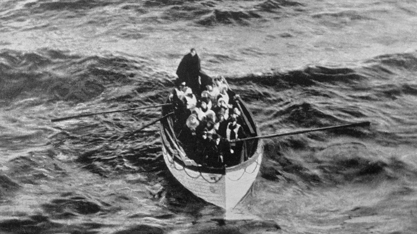 An emergency cutter lifeboat carrying a few survivors from the Titanic, seen floating near the rescue ship Carpathia on the morning of April 15, 1912, hours after the disaster. Titanic did not carry enough lifeboats to save all her passengers, and many of the available boats were launched carrying fewer than their 65-passenger capacity.