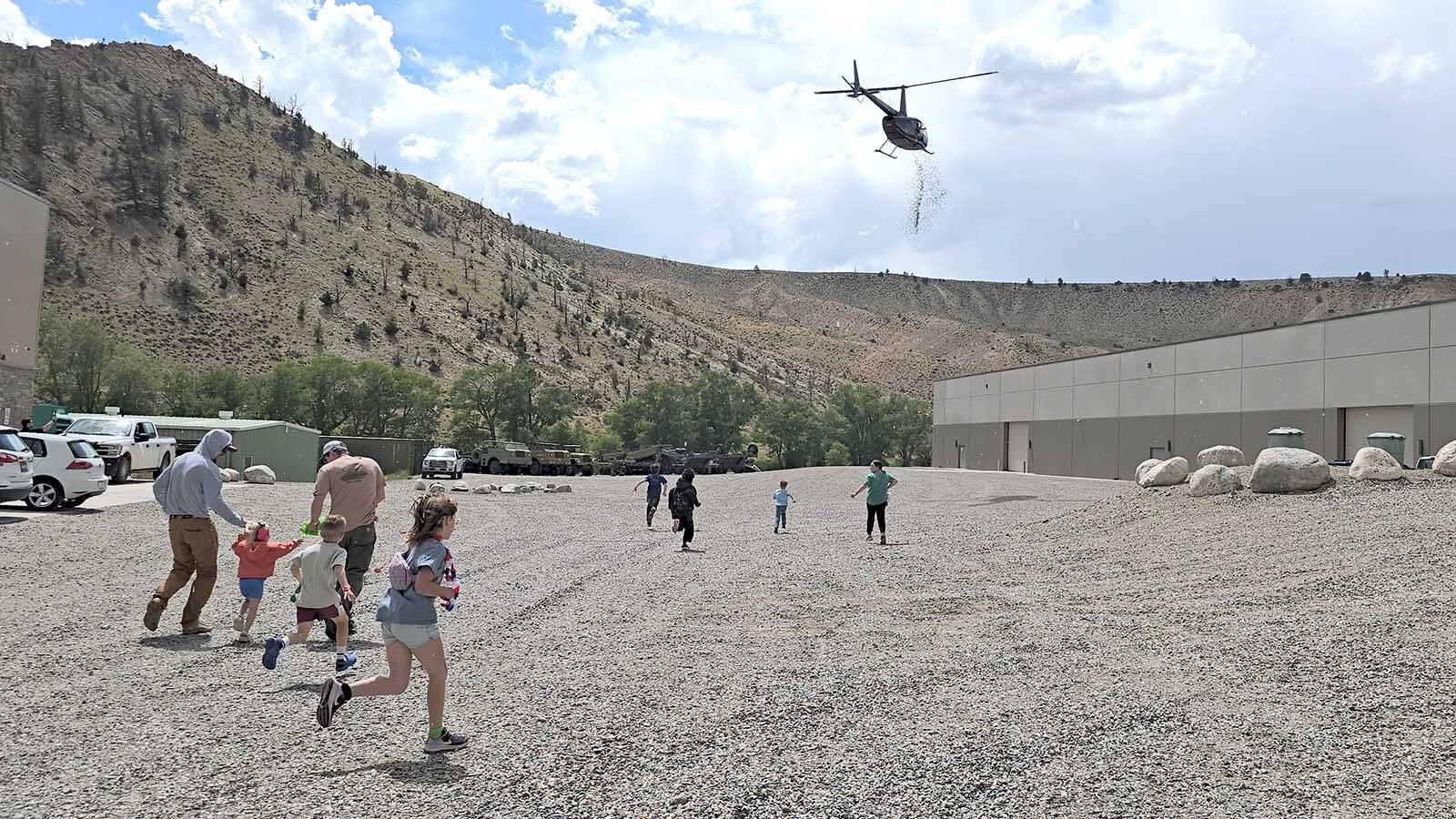 Children run as fast as they can to get to the Tootsie rolls this helicopter is dropping at the National Museum of Military Vehicles.