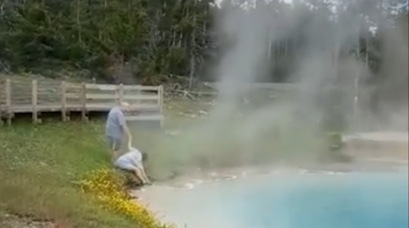 This image capture from a video posted to the Tourons of Yellowstone Instagram account shows a pair of Yellowstone visitors dangerously close to a 175-degree thermal pool.