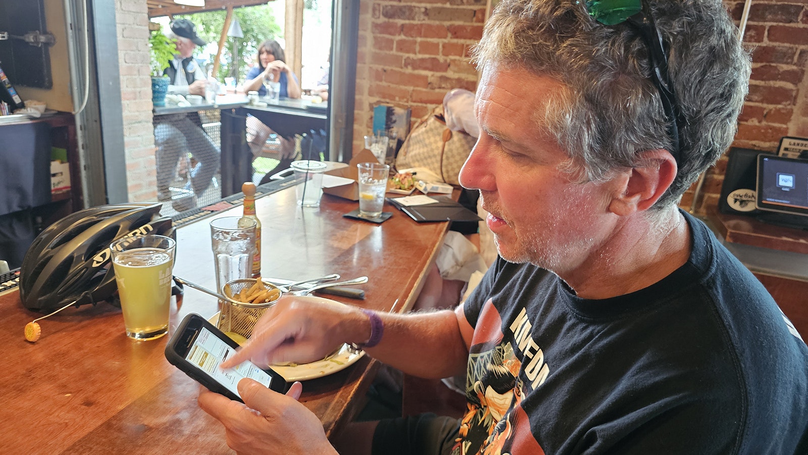 Mark Ryan talks with Cowboy State Daily about the Tour de Wyoming over a green chili burger and a beer at the Cowfish restaurant in Lander.