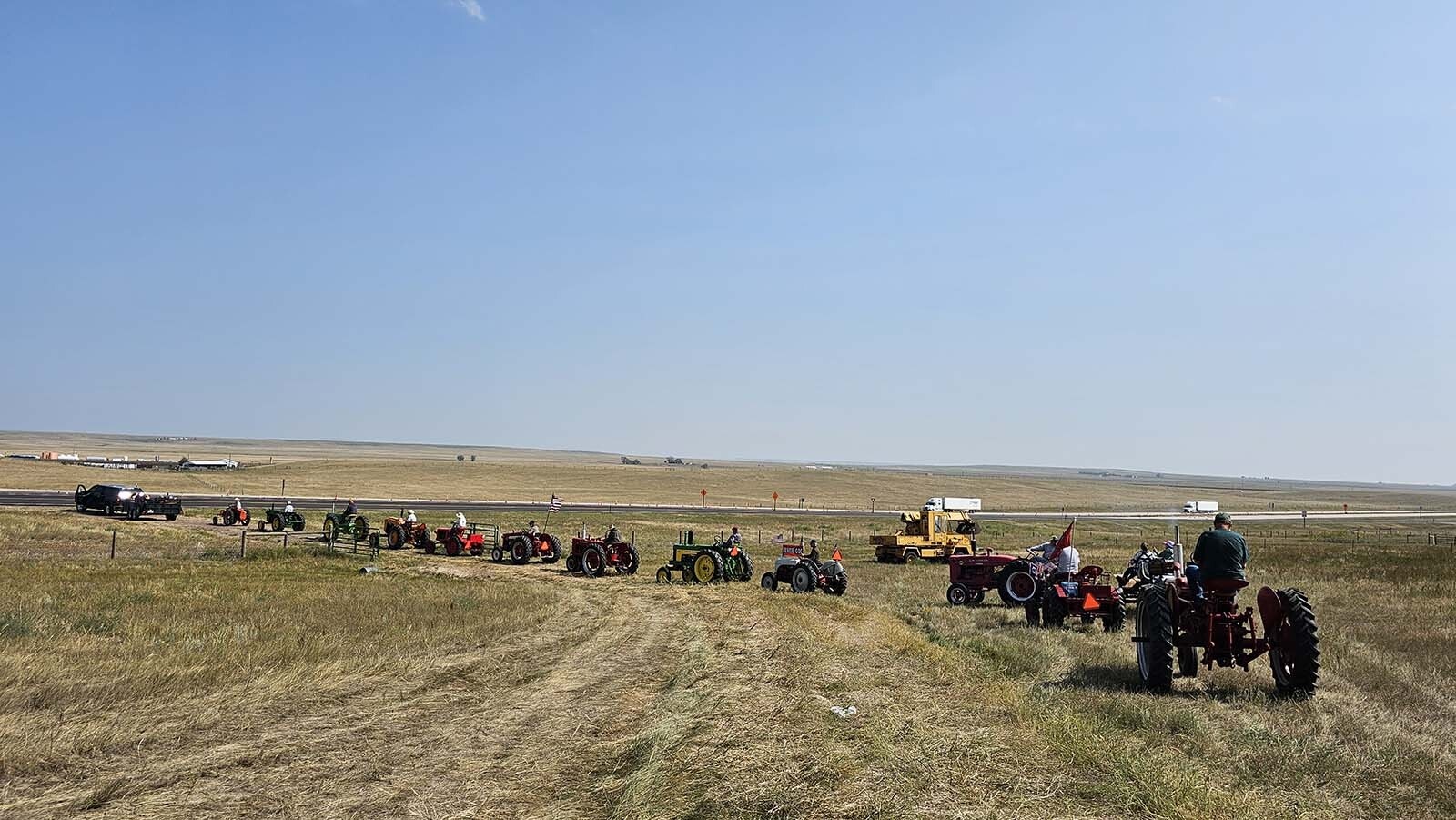 An impromptu parade of tractors takes off from a field near Burns for the annual tractor drive of the Centennial Antique Tractor and Engine Club.