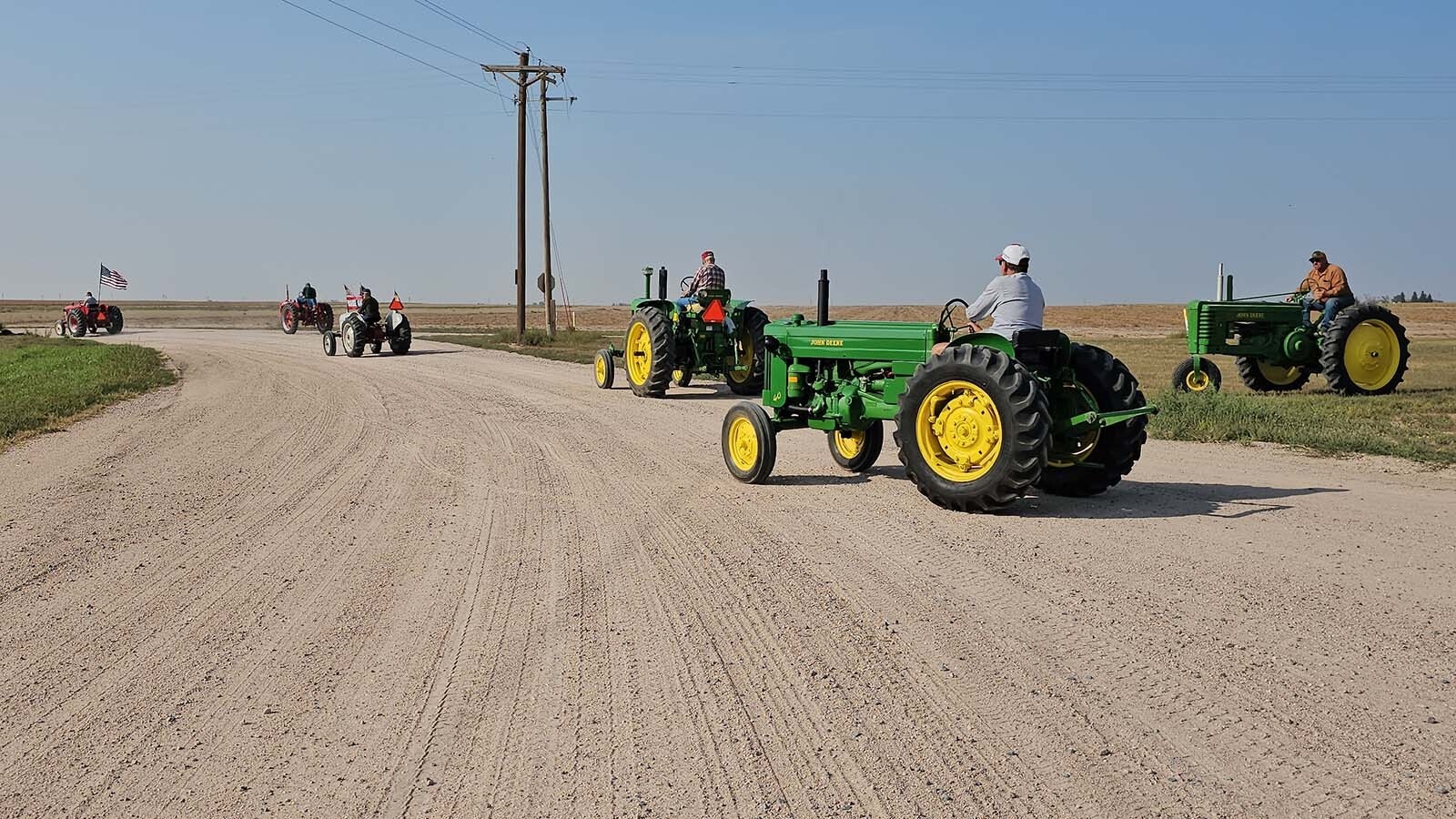 Tractors leaving Burnette Enterprises during the annual tractor drive for the Centennial Antique Tractor and Engine Club start to form up a mini parade for the journey home.