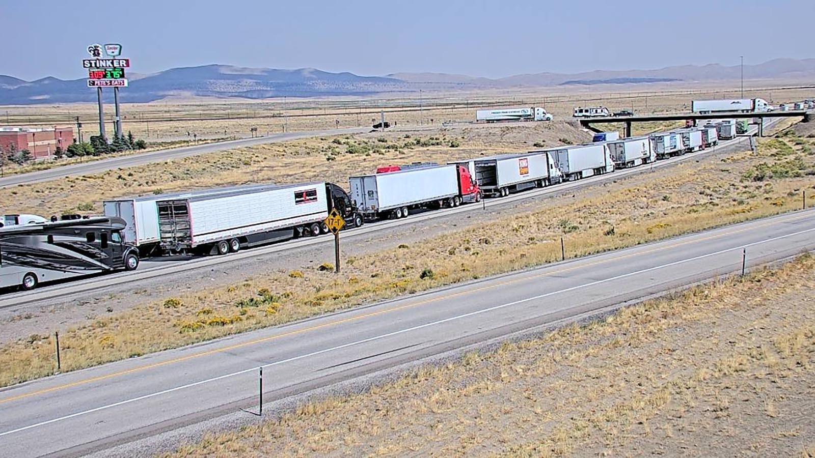 This screenshot from a WYDOT webcam at the exit just east of Sinclair, Wyoming, shows a long line of cars waiting for the highway to reopen.