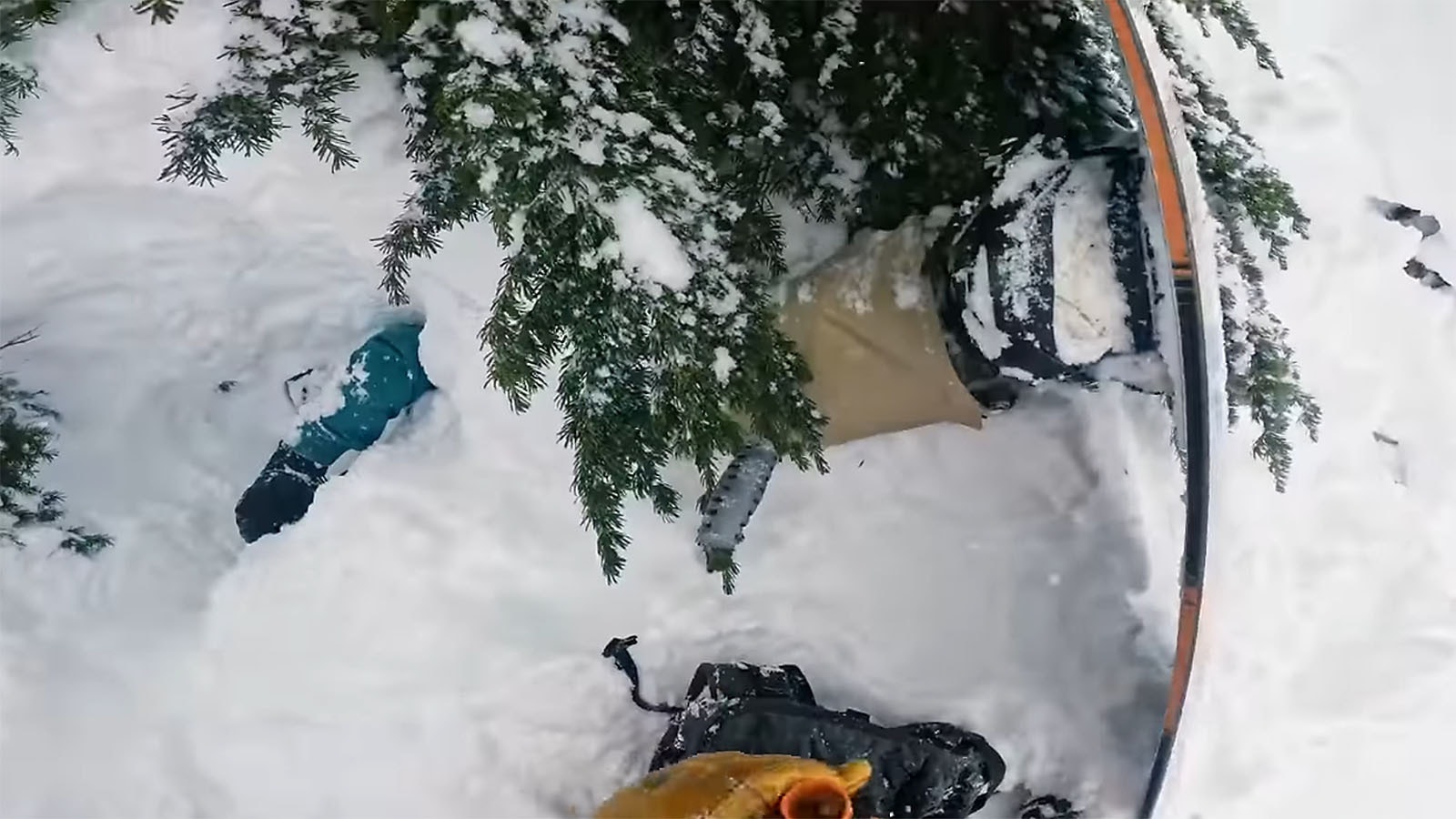 This image from Francis Zuber's GoPro camera shows Zuber working to dig an upside-down snowboarder out of a deep tree well.