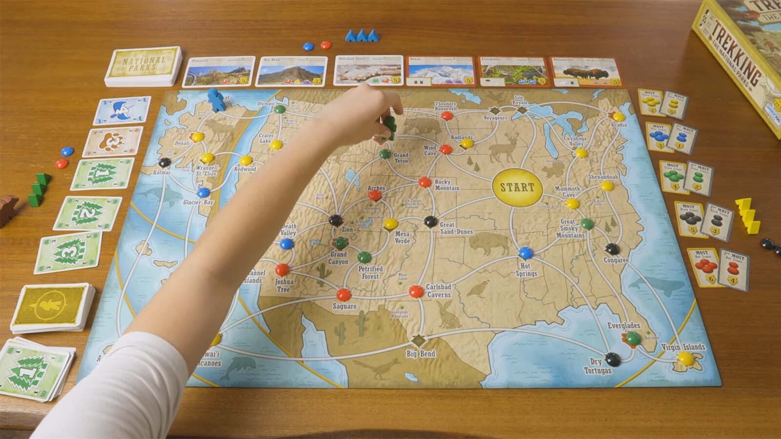 A player moves through Yellowstone on the Trekking the National Parks board game layout.