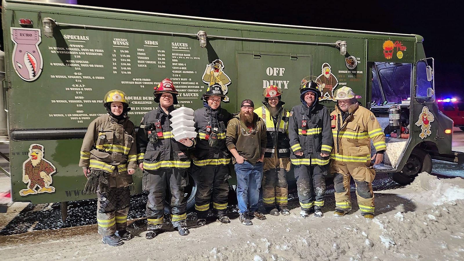 Weizens Wings owner Trend Weitzel, center, with members of the Vedauwoo Volunteer Fire Department on Sunday after stopping at the scene of a car fire Sunday to feed the crews at the scene.