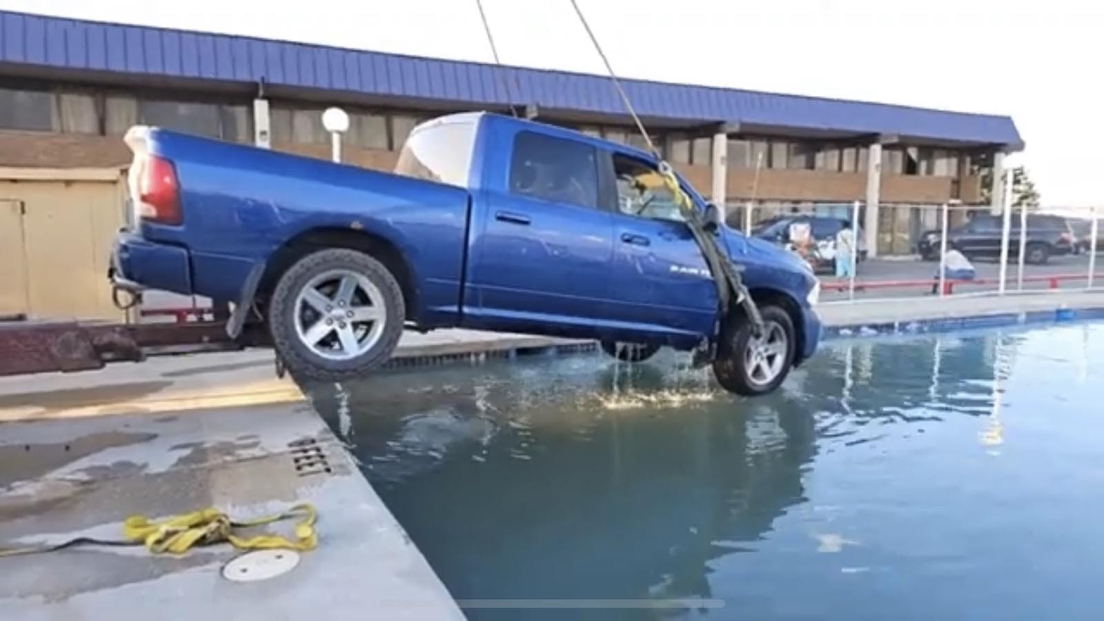 A wrecker pulls a large Dodge Ram truck out of the outdoor pool at the National 9 motel in Gillette.