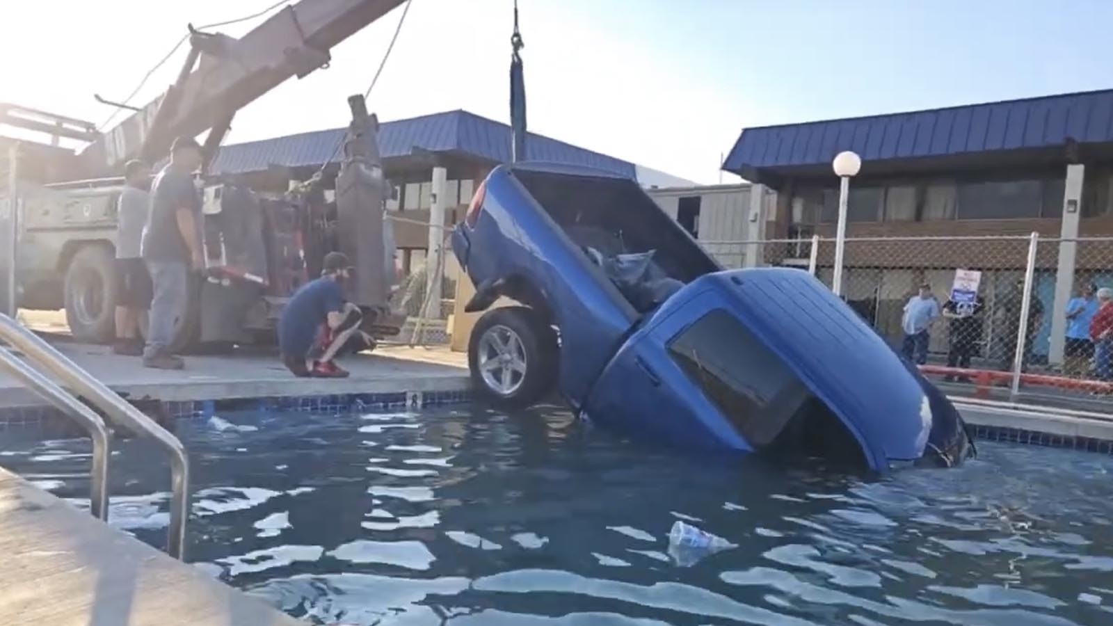A wrecker pulls a large Dodge Ram truck out of the outdoor pool at the National 9 motel in Gillette.