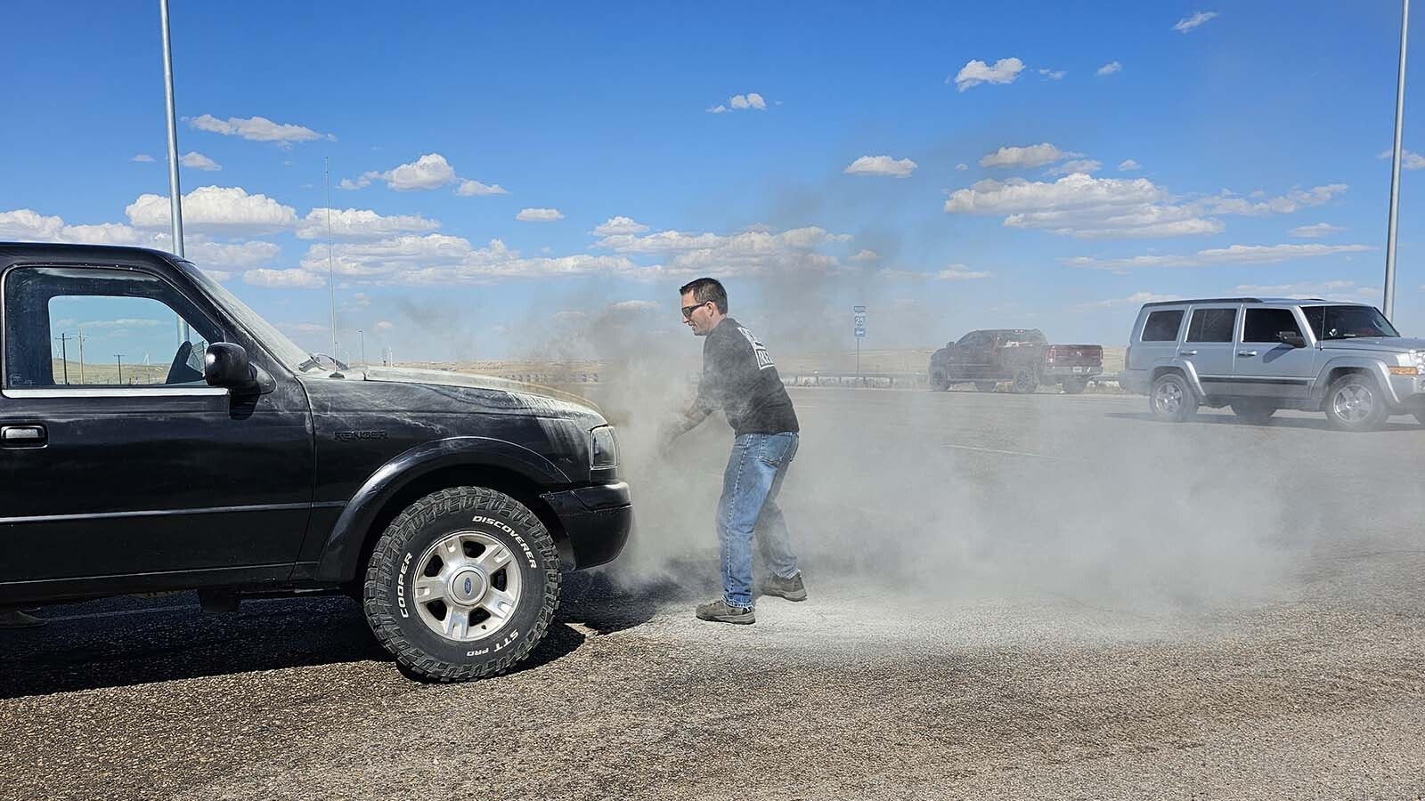 Nathan Frederick puts a fire extinguisher a passing semi truck driver gave him to good use, tamping down a fire that started under the hood. That allowed him to get the hood open, so he could see what was going on and douse the engine with water.