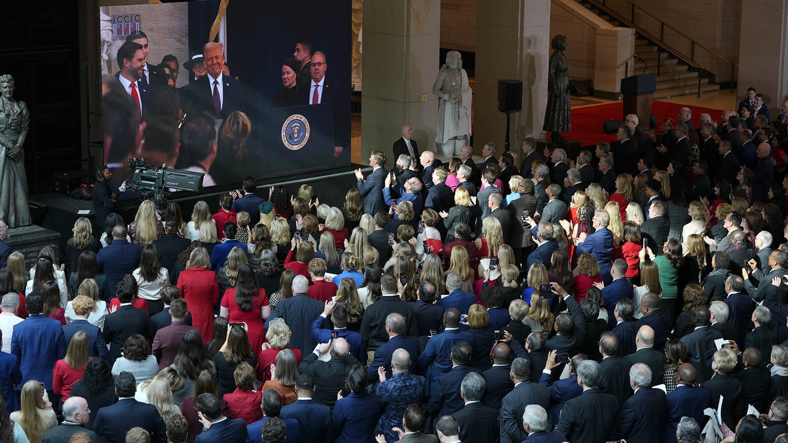 Guest watch as President-elect Donald Trump is seen on screen in the VIP viewing area in Emancipation Hall for the Inauguration of Donald J. Trump in the U.S. Capitol Rotunda on Jan. 20, 2025, in Washington, D.C. Donald Trump takes office for his second term as the 47th president of the United States.