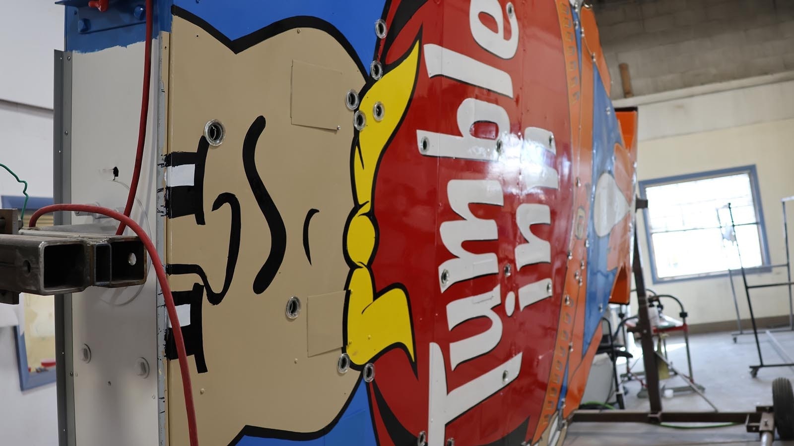 The sign currently is held on a rotisserie-like device that allowed for his painting and other work.