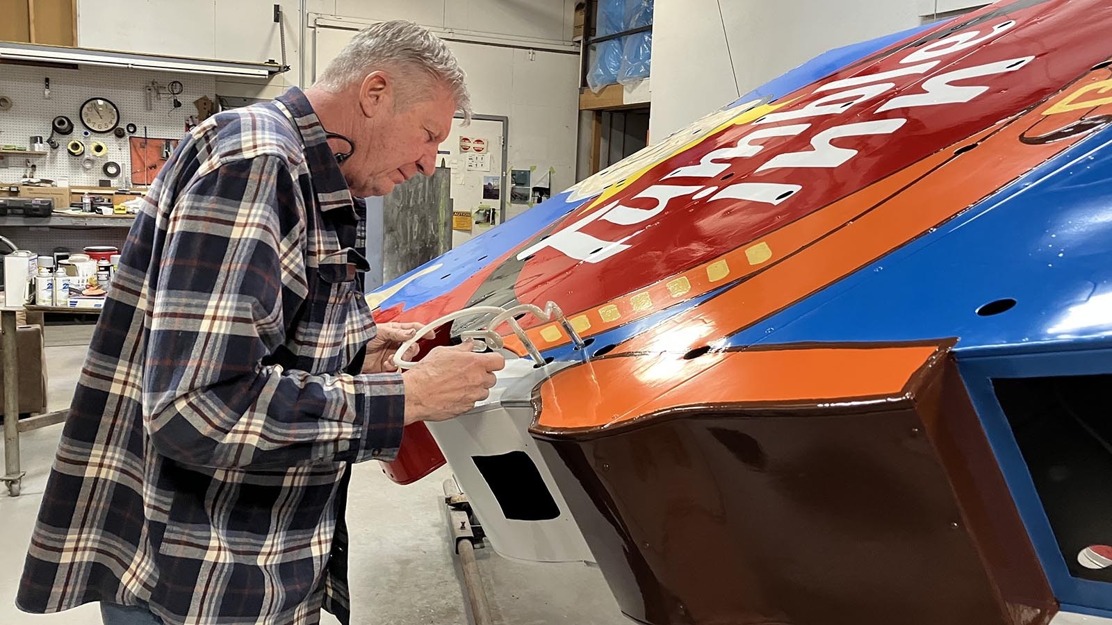 John Huff checks to ensure a piece of neon glass that is part of the Tumble Inn sign fits in the right place.