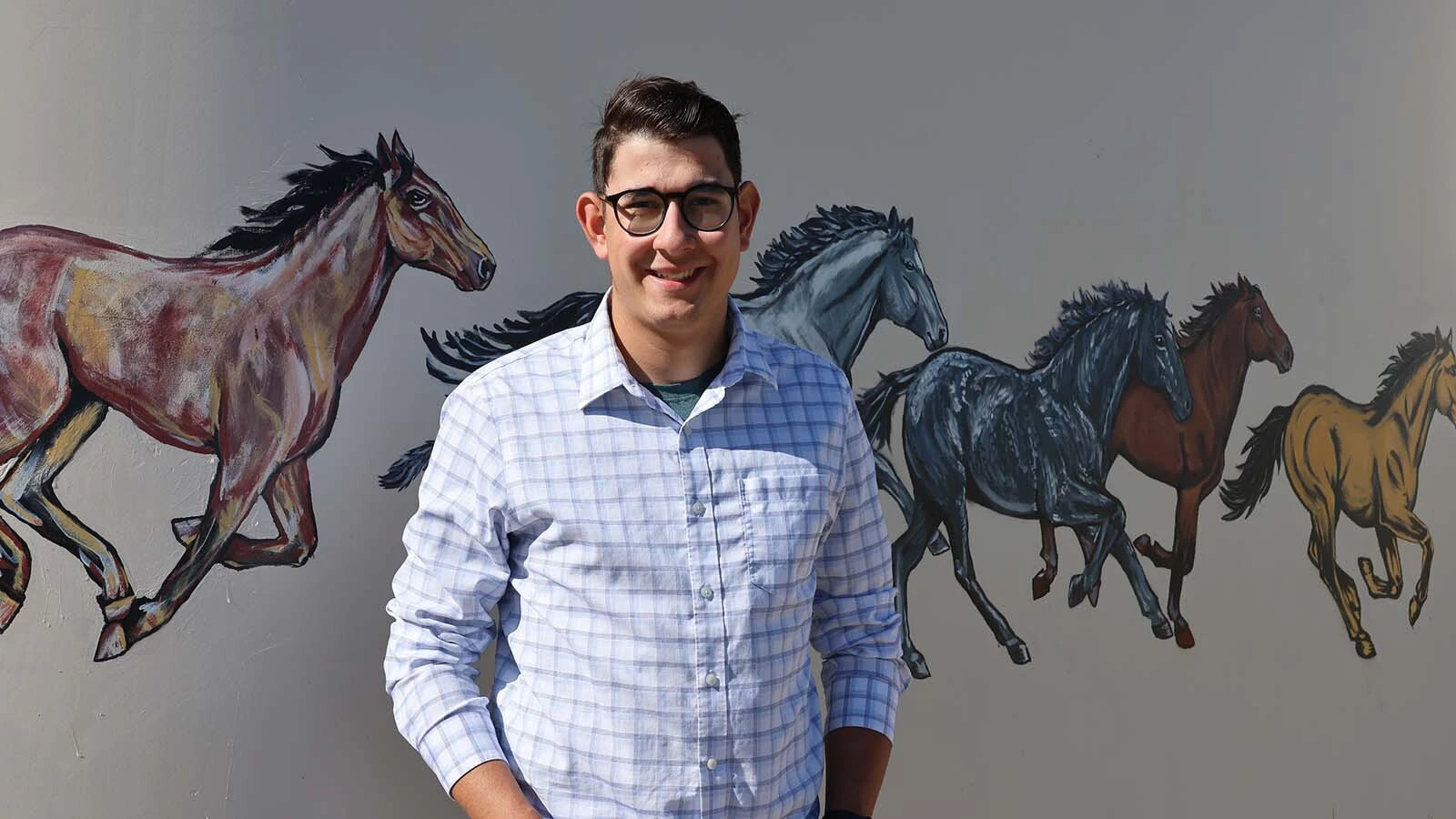 Wyoming Rescue Mission resident Andrew Santor said the experience of helping create the art was “cool.” He is standing by the horses he painted.