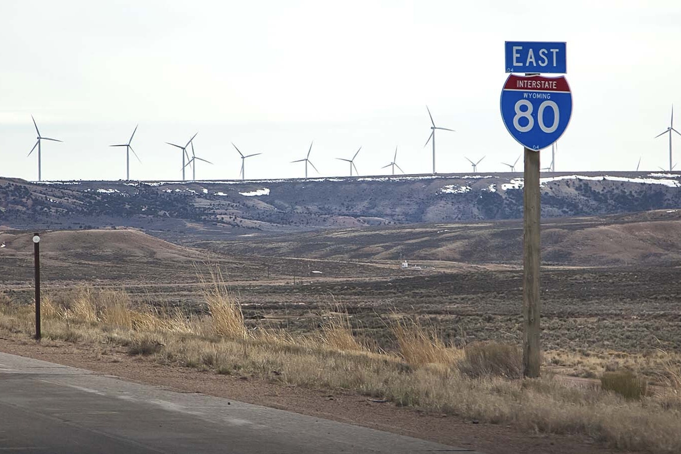 A row of wind turbines visible driving east on Interstate 80 across southern Wyoming.