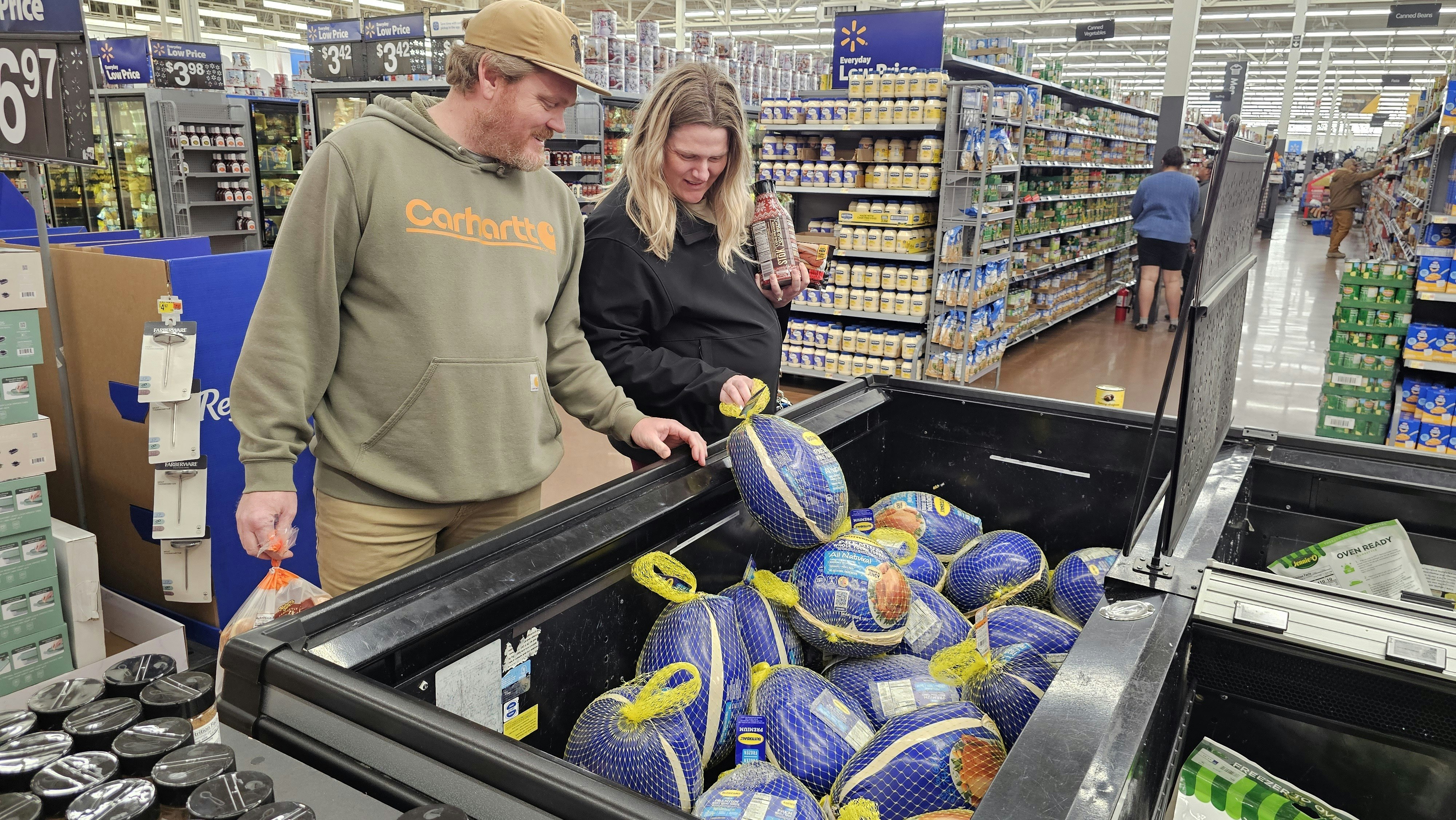 Jordan and Kaylin Birdwell scope out the price of a whole bird, after realizing the price for a smaller, turkey breast roast, is much more expensive per pound. Store specials are keeping the price of whole birds in check, in spite of avian flu decimating turkey flocks.