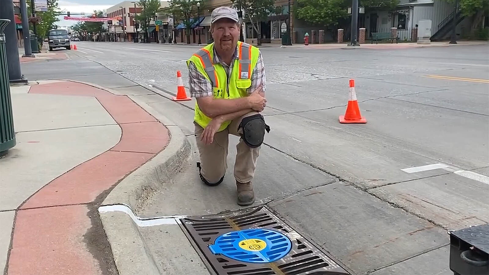 Brian Deurloo with a gutter bin his company installed, branded by the Sheridan Rotary Club. Deurloo's innovative storm drain inserts filter trash out before it can get into the city's water system.