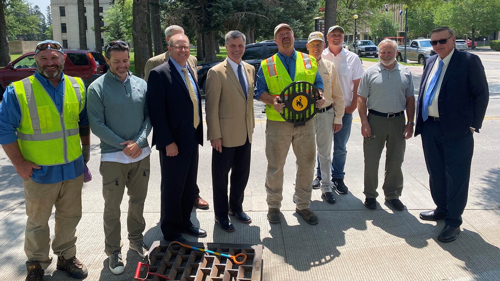 Brian Deurloo holds a gutter bin lid during a ceremony to mark the install of the devices around the Wyoming Capitol.