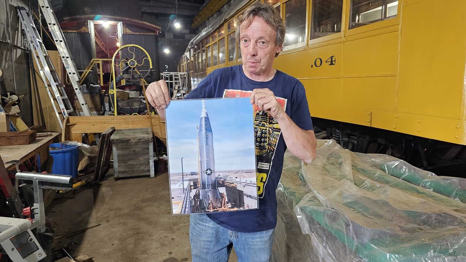 Michael Pannell holds up a picture of an old Atlas missile, which he has hanging up in his train restoration workshop. At some point he'd like to turn one of the three missile silo sites into a museum.