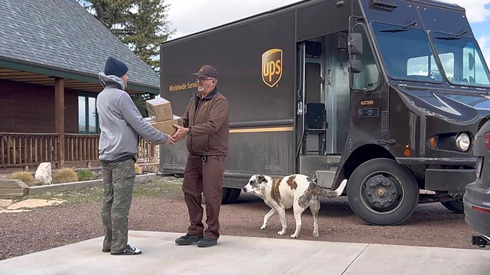 James Cary Lambert hands off a package to one of his customers on his last day after 33 years of delivering for UPS, the last 15 on the Happy Valley route.