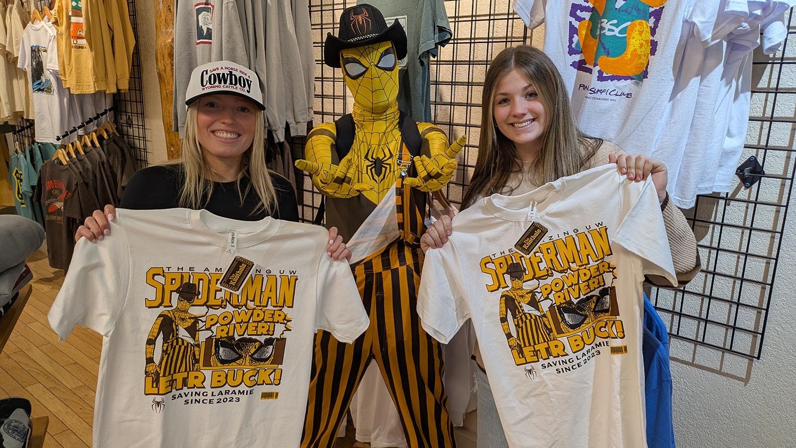 Madie Baillie, UW Spiderman, and Sara Sullivan show off the Knothole's special edition T-shirt for this weekend's big event.