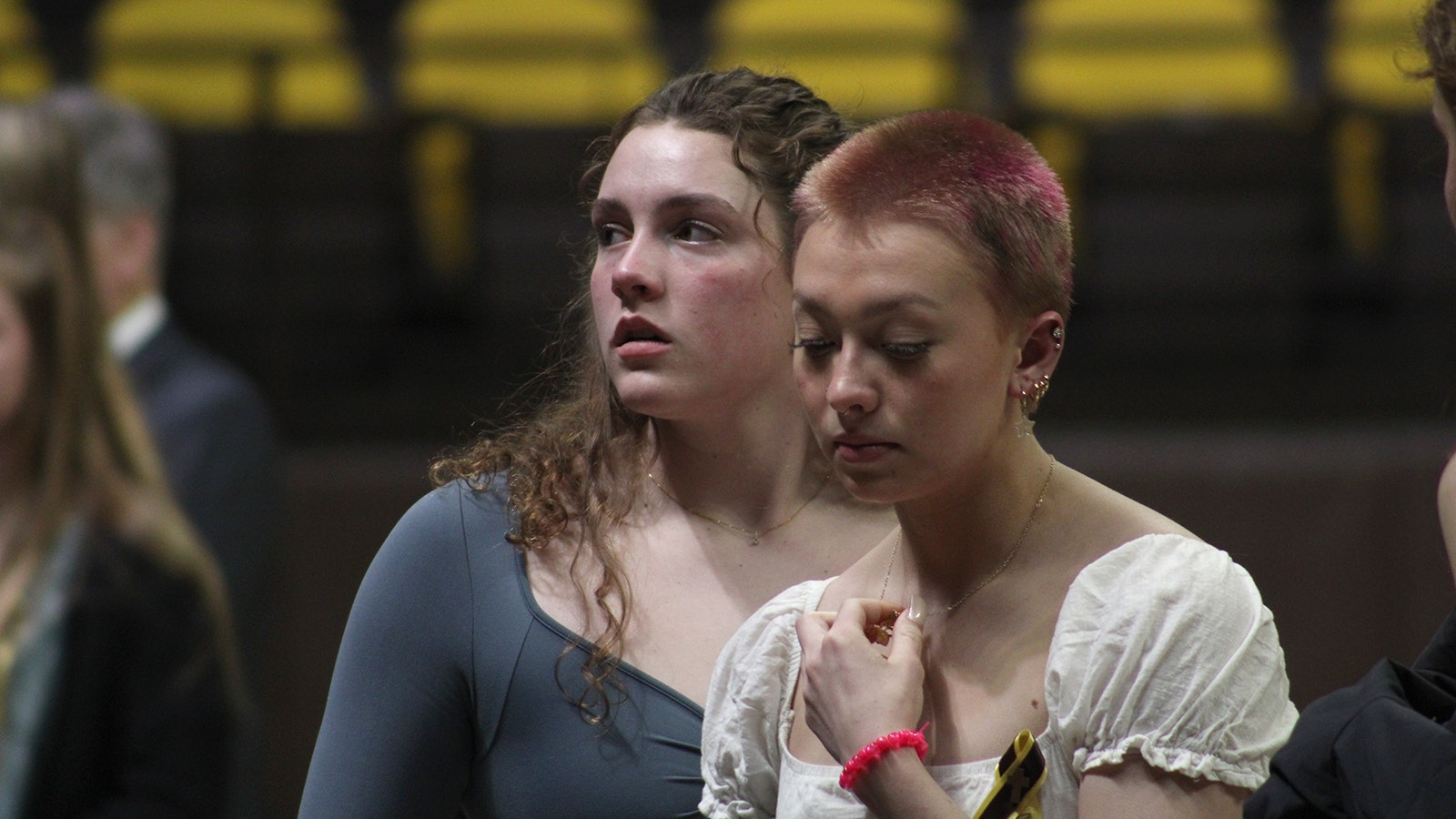 University of Wyoming women's swim team members Sydney Metzler, left, and Sydney McKenzie at a Wednesday memorial service for three teammates who died in a car crash Feb. 22, 2024.