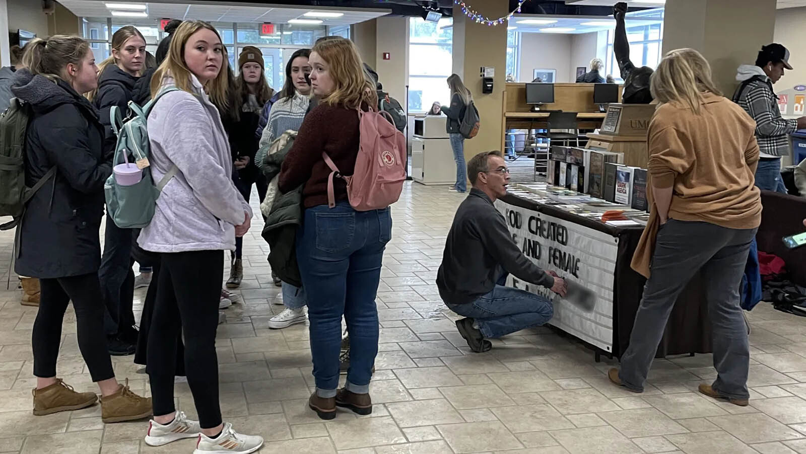 Todd Schmidt covers the name of a transgender sorority member on a sign on his table in the UW Student Union in December.