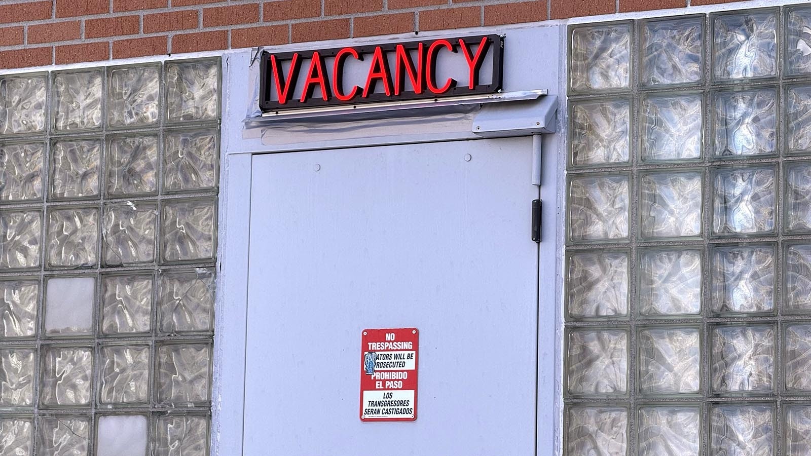 A motel-style "vacancy" sign flashes red over the north door of the Laramie County jail at the intersection of Pioneer Avenue and 20th Street in downtown Cheyenne.