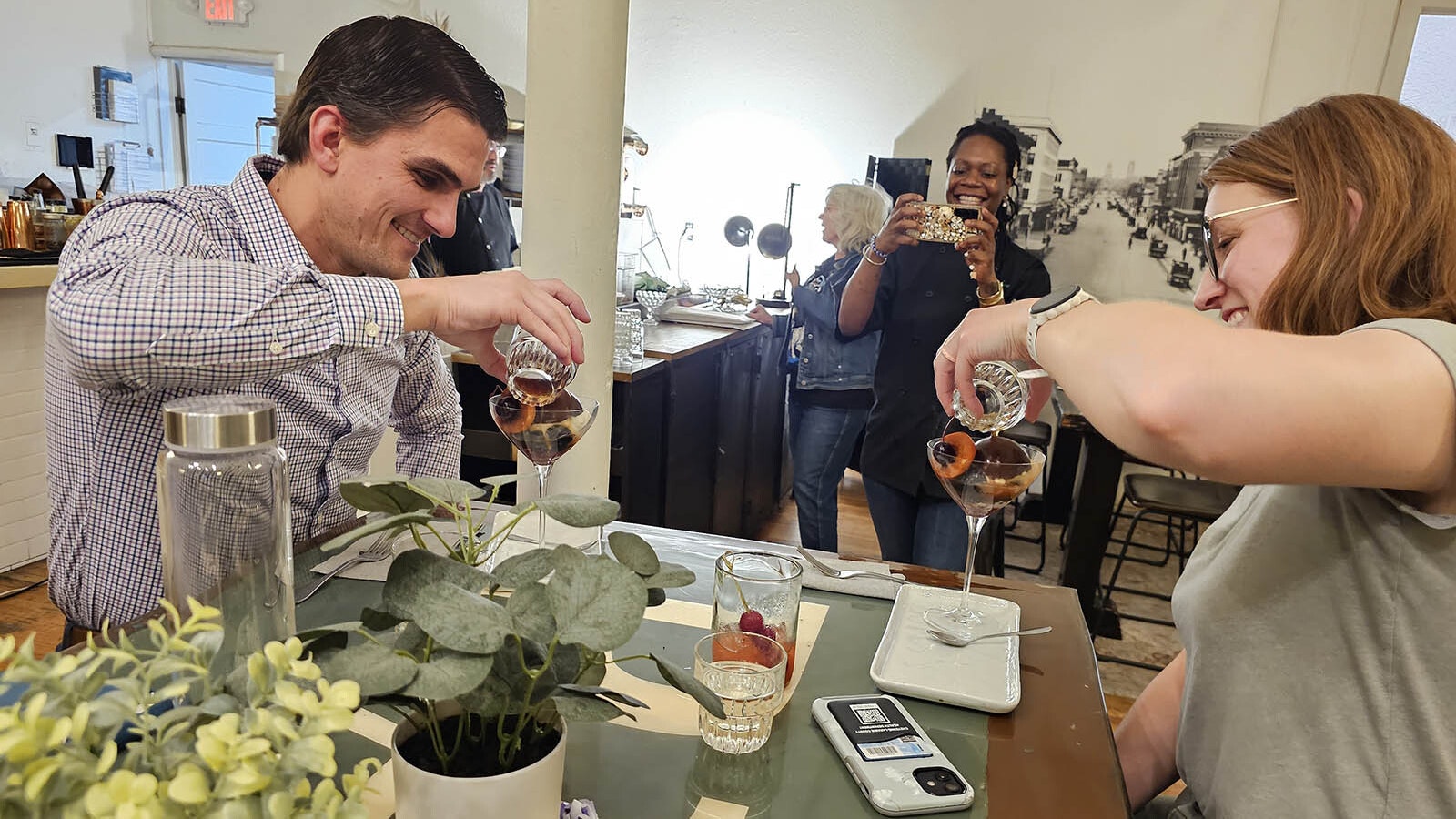 Chef Petrina Peart, background, makes a video of two guests, pouring whiskey-spiked espresso over a chocolate shell that's hiding hazelnut ice cream with crunchy hazelnuts and a surprise ingredient, Pop Rocks.