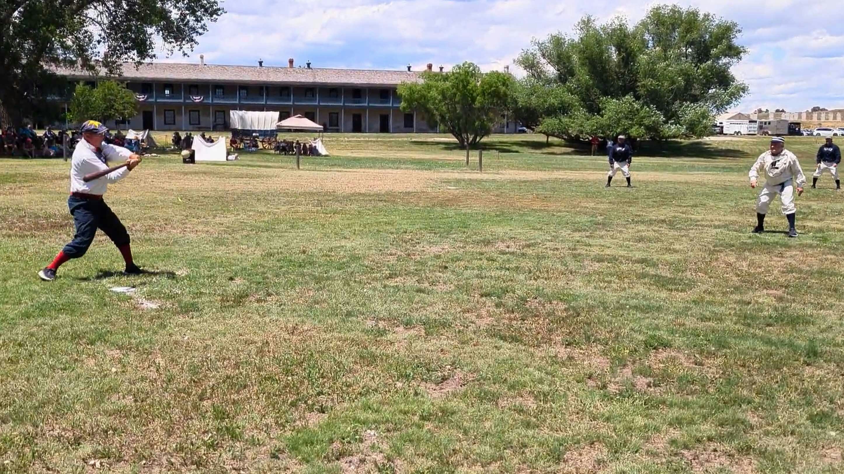 A batter strikes a ball during a demonstration of the National Pastime under the rules of the 1860s during the Fort Laramie National Historic Site Independence Day celebration.