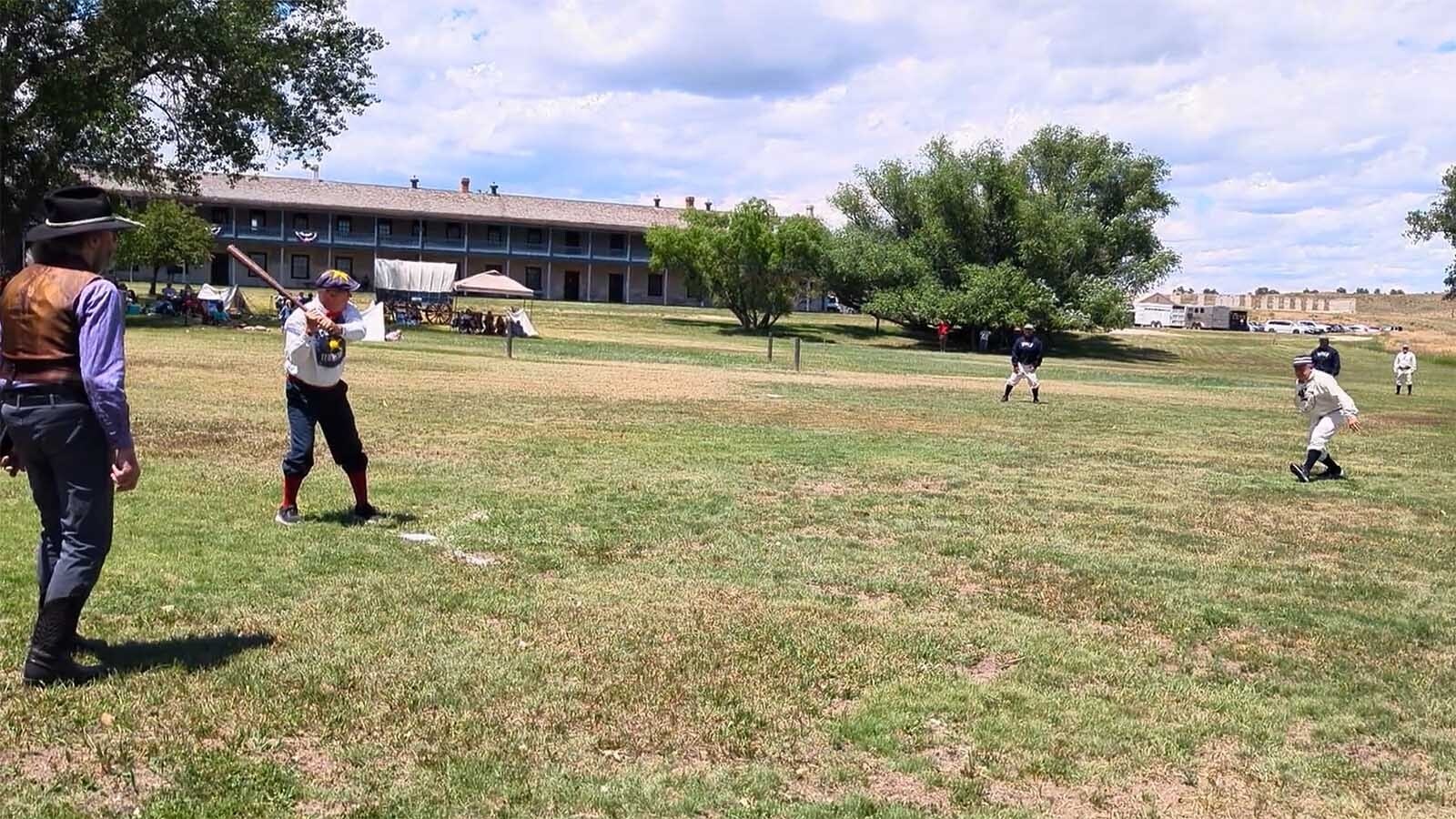 A batter strikes a ball during a demonstration of the National Pastime under the rules of the 1860s during the Fort Laramie National Historic Site Independence Day celebration.