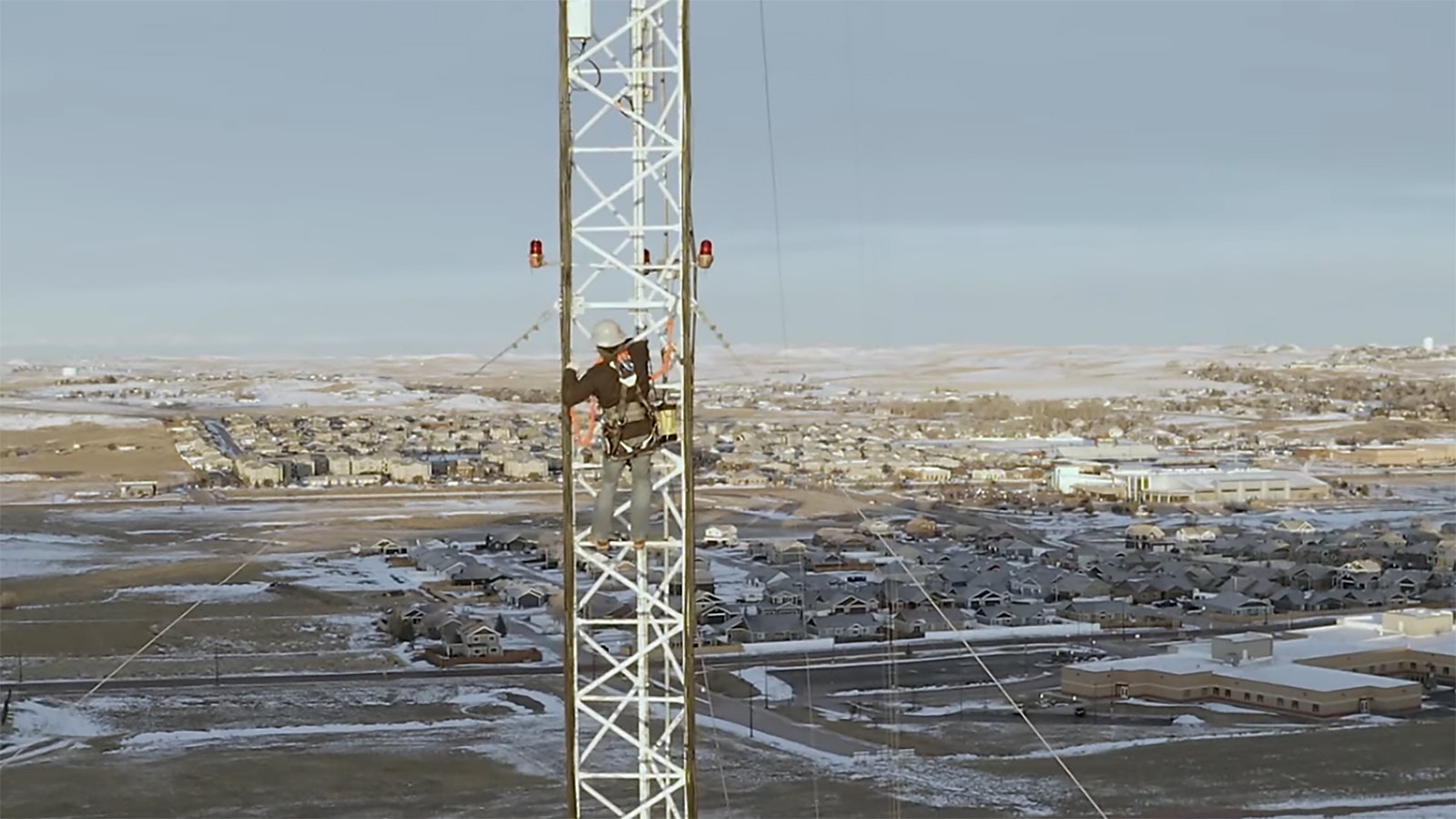 A Visionary Broadband technician climbs a communications tower.
