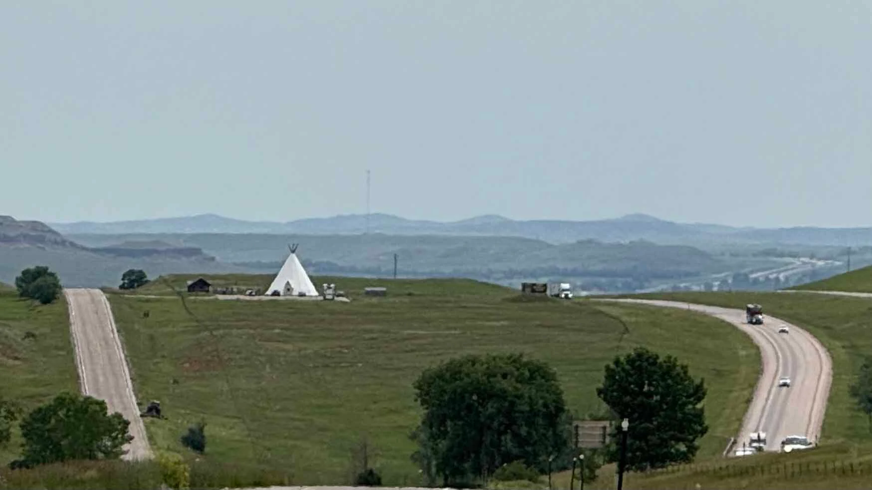 The Vore Buffalo Jump and I-90 looking east. The intended route of I-90 was rerouted, from the north to the south of the sinkhole, after a 20-foot layer of bison bones was found at the bottom of it. 