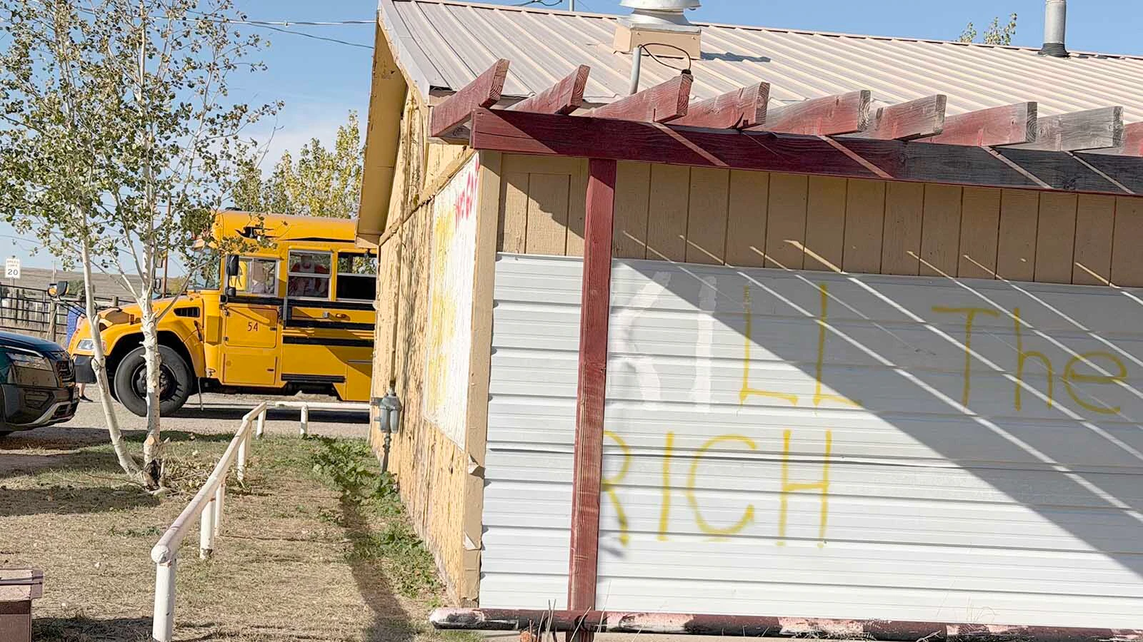 A school bus pulls alongside the old Lazy 8 east of Casper on Monday afternoon, where profane political messages have been painted across the former saloon.