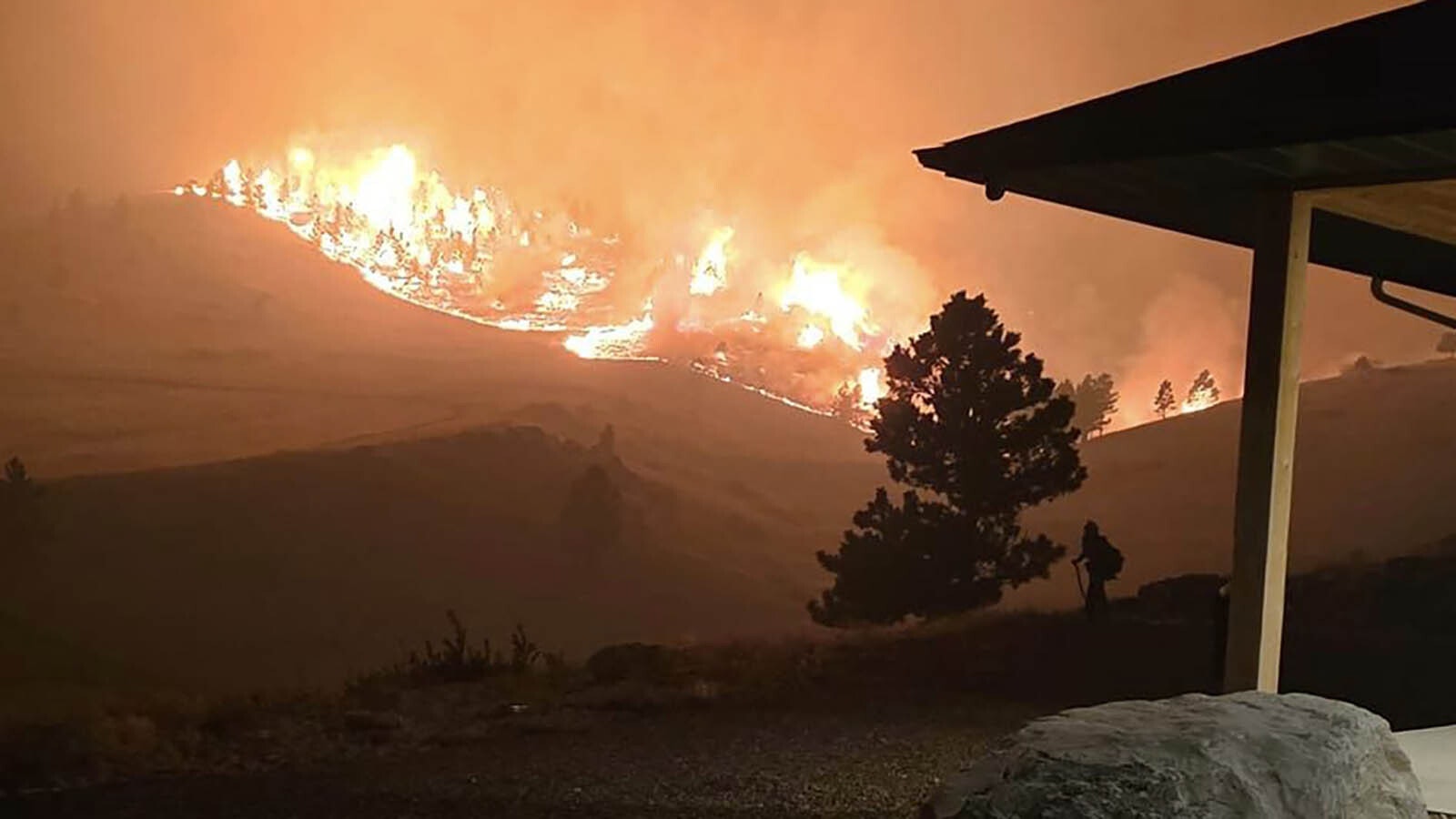 The Elk Fire rages around Warren Titschler's home near Dayton, Wyoming. With a hose and a water tank, he protected it through a frightening night of out-of-control wildfire activity.