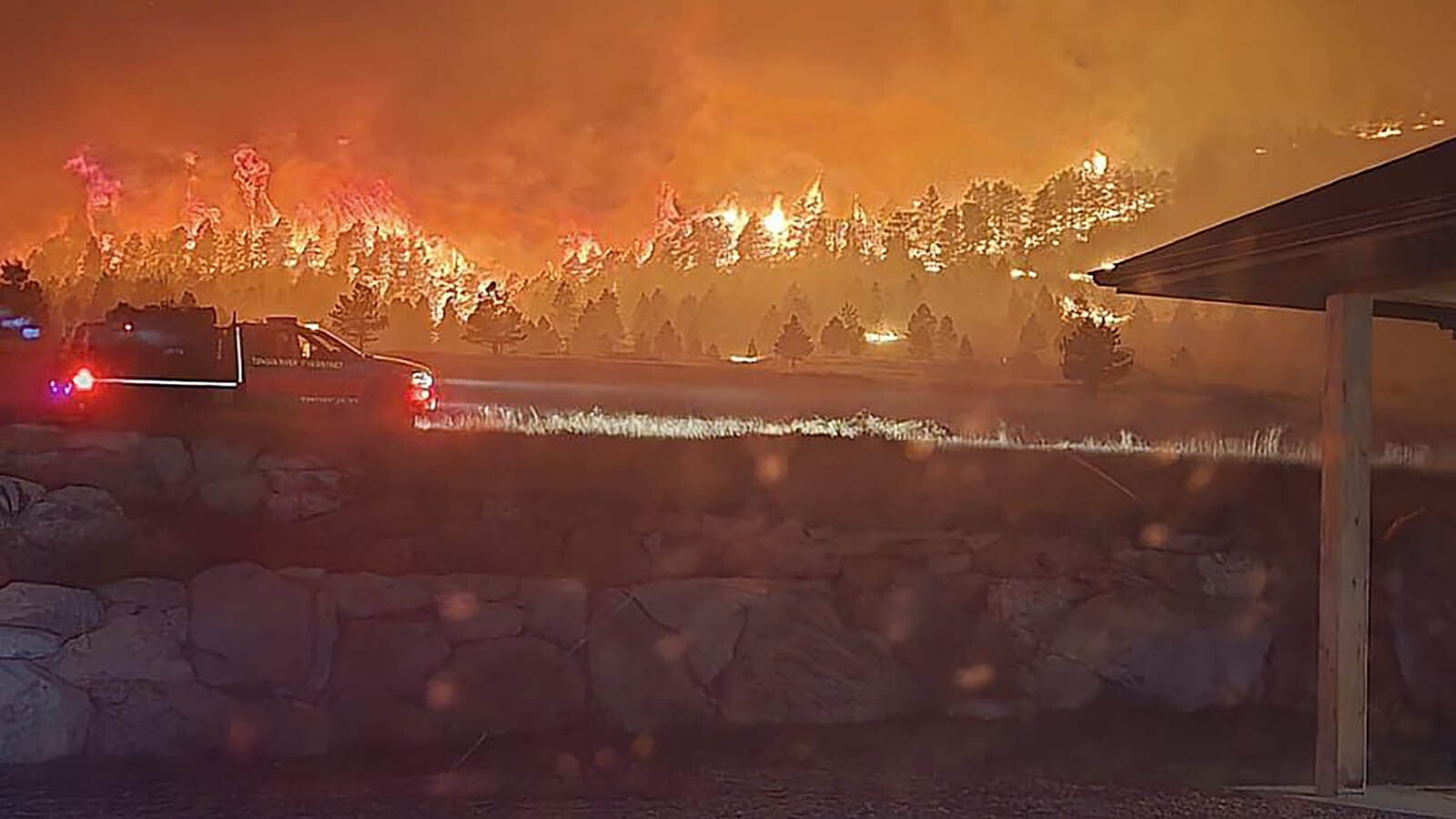 The Elk Fire rages around Warren Titschler's home near Dayton, Wyoming. With a hose and a water tank, he protected it through a frightening night of out-of-control wildfire activity.