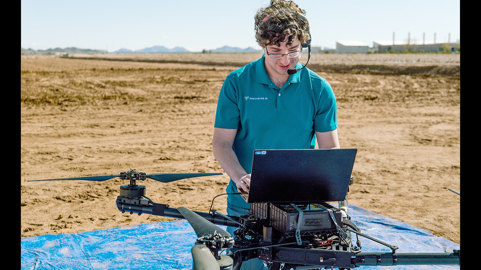 A staffer from Precision AI works with a drone the company operates to detect heavy spurge, an invasive weed.