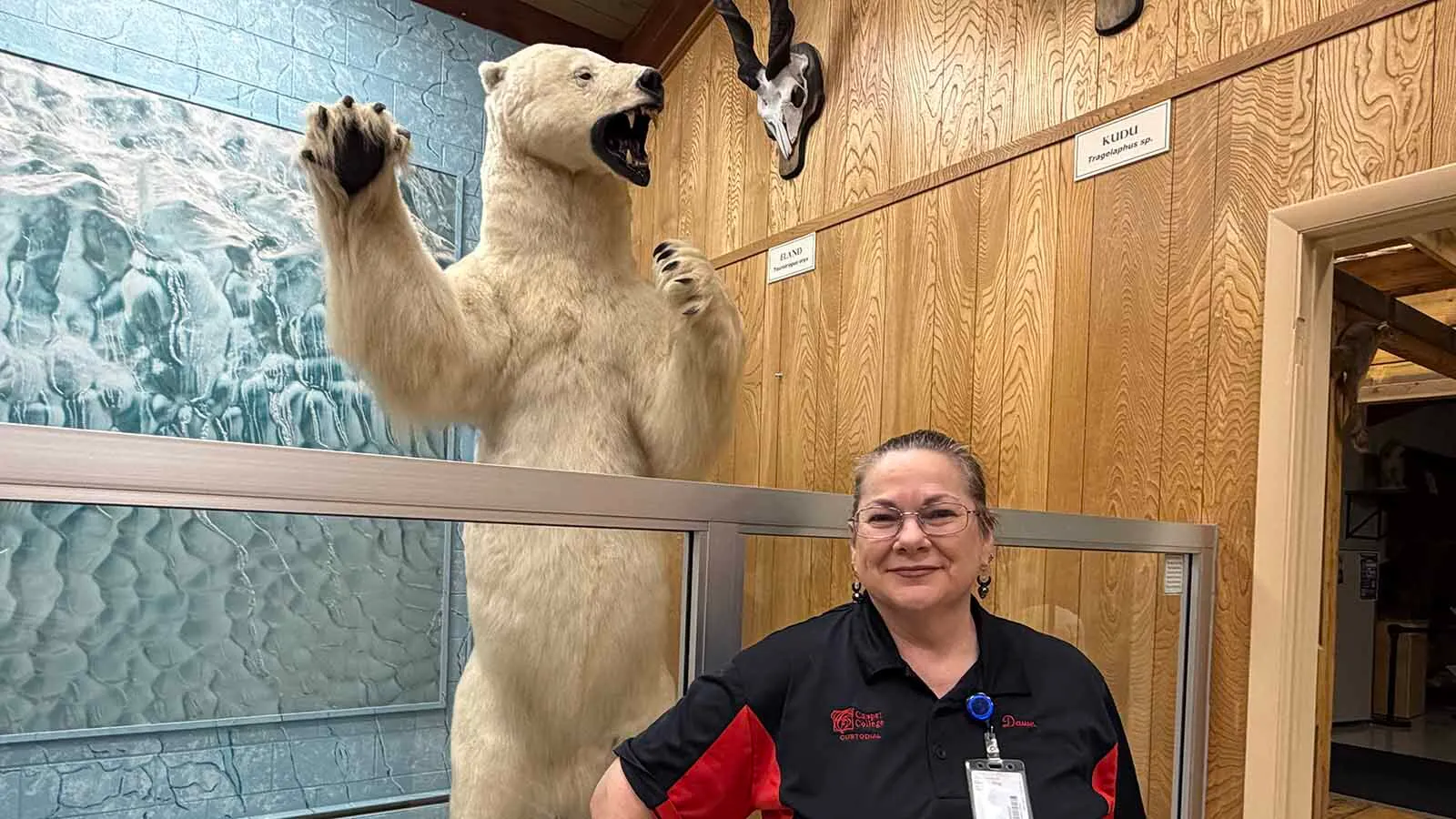 Casper College custodial worker Dawn Francis stands beside a towering polar bear at the Werner Wildlife Museum. Francis has spent years cleaning the museum after hours, alone among its hundreds of taxidermied residents.