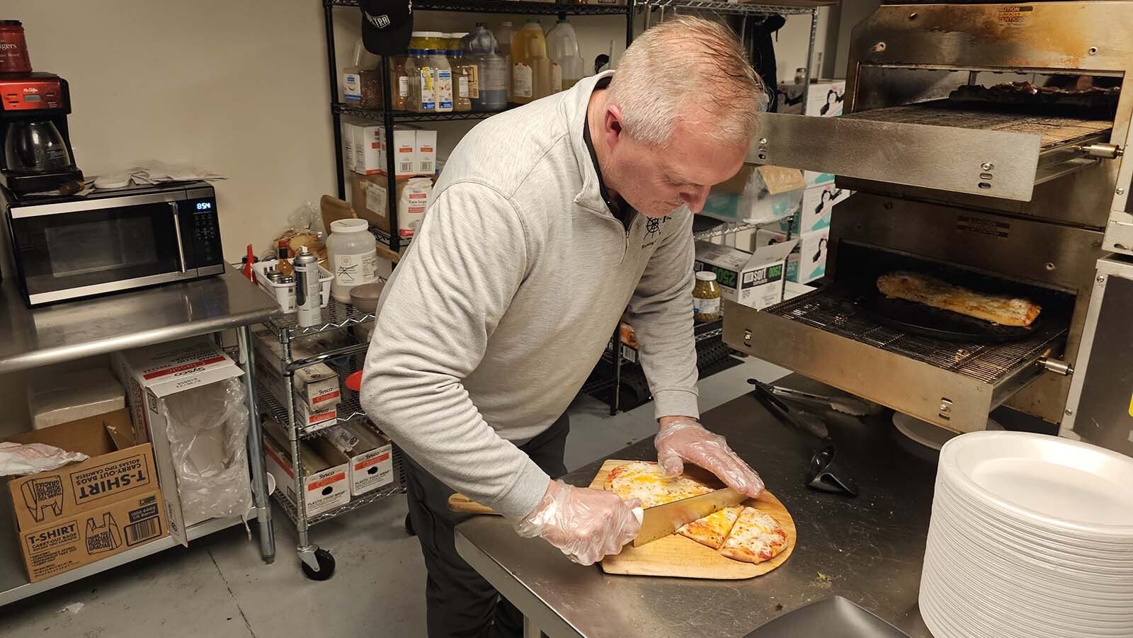 Darin Westby slices a pizza fresh out of the oven at Westby Edge Brewing Co.
